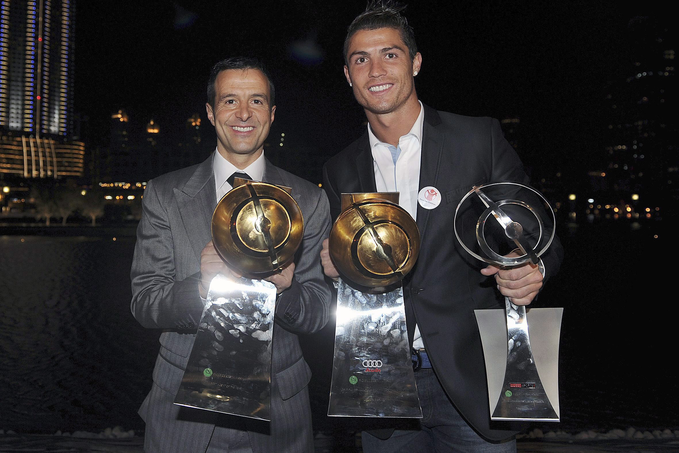 DUB03. DUBAI (EMIRATOS ÁRABES UNIDOS), 28/12/11.- El jugador de Portugal Cristiano Ronaldo (d) del Real Madrid y su manager orge Mendes (i) posan con los trofeos que le fueron entregados a Ronaldo hoy, 28 de diciembre de 2011, durante la ceremonia de los Premios Globo de Fútbol en Dubai (EAU). EFE/ JORGE MONTEIRO  EAU FÚTBOL